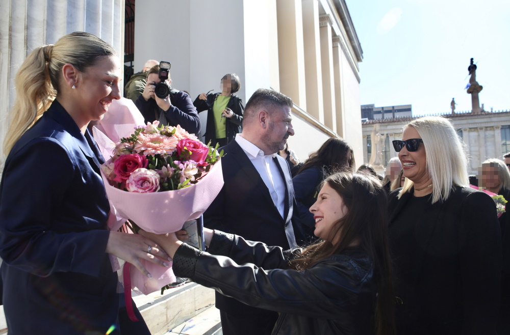 Η Ιωάννα Χαρδαλιά χαμογελά στην αδελφή της, Δήμητρα που της προσφέρει μια όμορφη ανθοδέσμη.