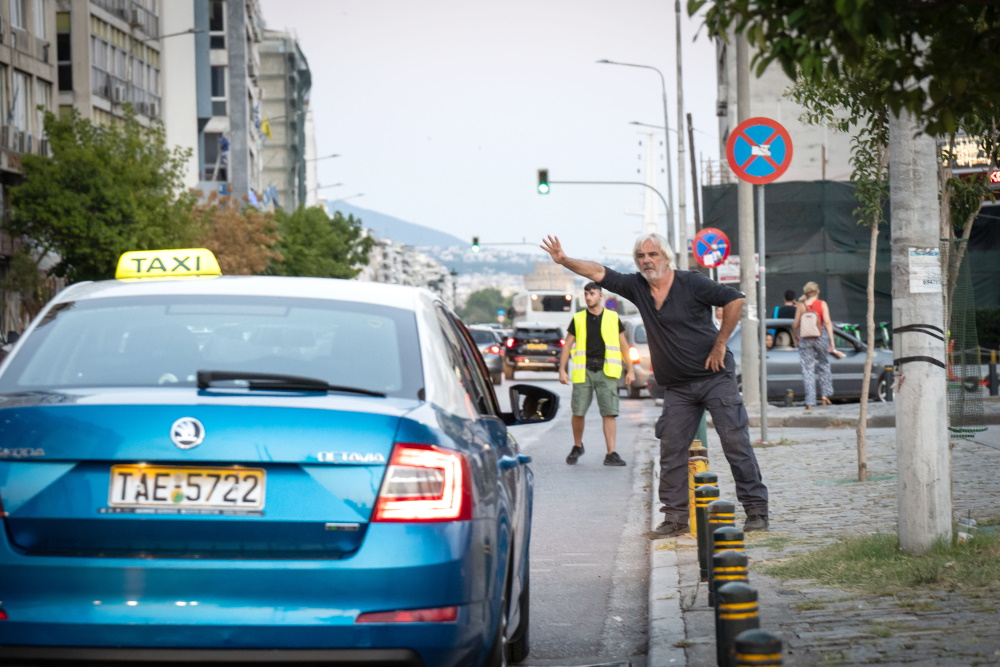 Ο Νίκος Αρβανίτης κατά τη διάρκεια γυρίσματος στη Θεσσαλονίκη σταματά ένα ταξί.